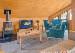 A cozy room with a fireplace, a TV, a coffee table, and comfortable seating.
