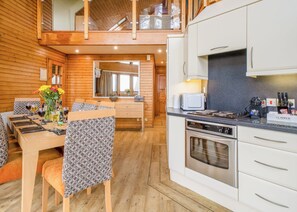 A wooden interior with a dining area, kitchen, and upper-level balcony. - 3 bedroom accommodation in Millom (Millom)