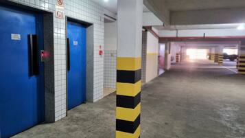 A parking garage with blue doors, a garage sign, and yellow and black striped columns.