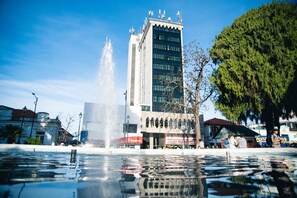 A fountain in a public square with a modern building in the background. - Lucape Palace Hotel (Barbacena)