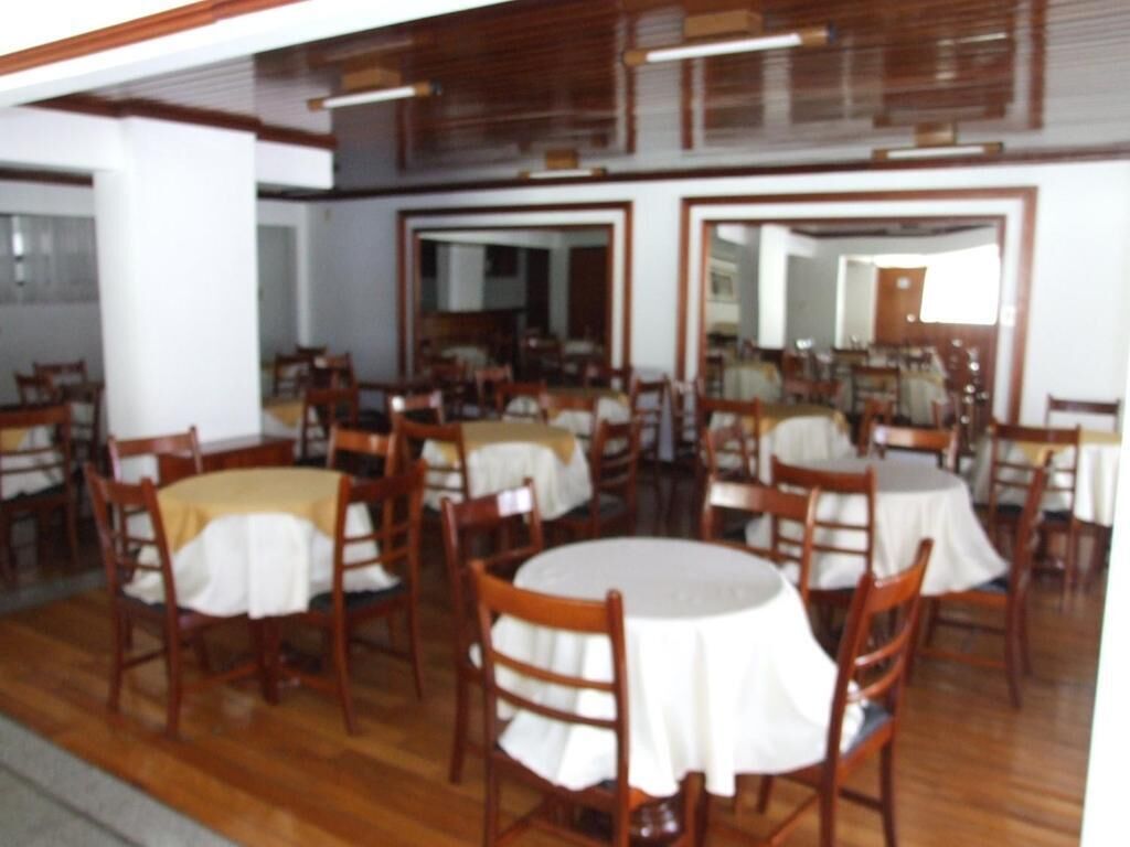 Un espace repas comprenant plusieurs tables rondes et des chaises en bois, disposées de manière à créer un aménagement spacieux.
