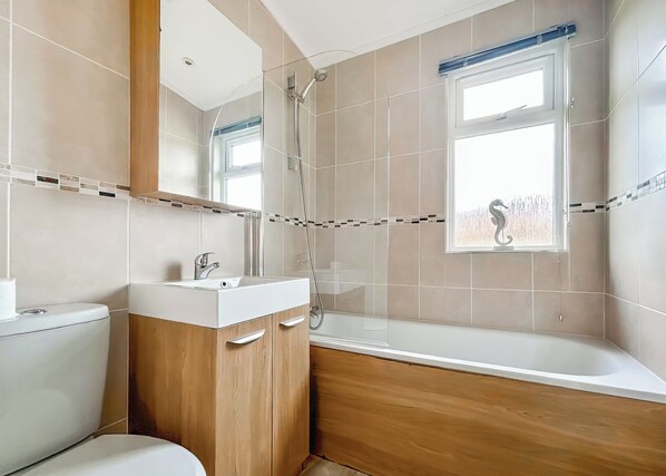 Ein Badezimmer mit Toilette, Waschbecken, Dusche und Badewanne.