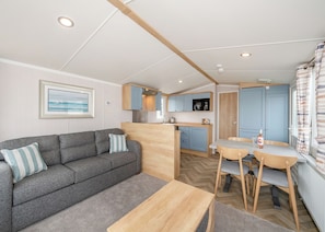 A compact living space with a sofa, a dining table, and a kitchenette.