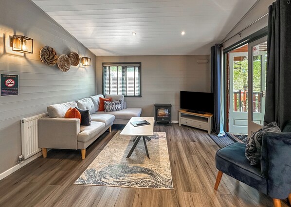 Una sala de estar con sofá, mesa de centro, televisión y chimenea.