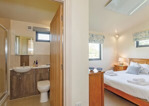 A bedroom with a bed, bedside table, and a window. - A stunning luxury lodge, perfect for a couples retreat or family break. (West Tanfield)