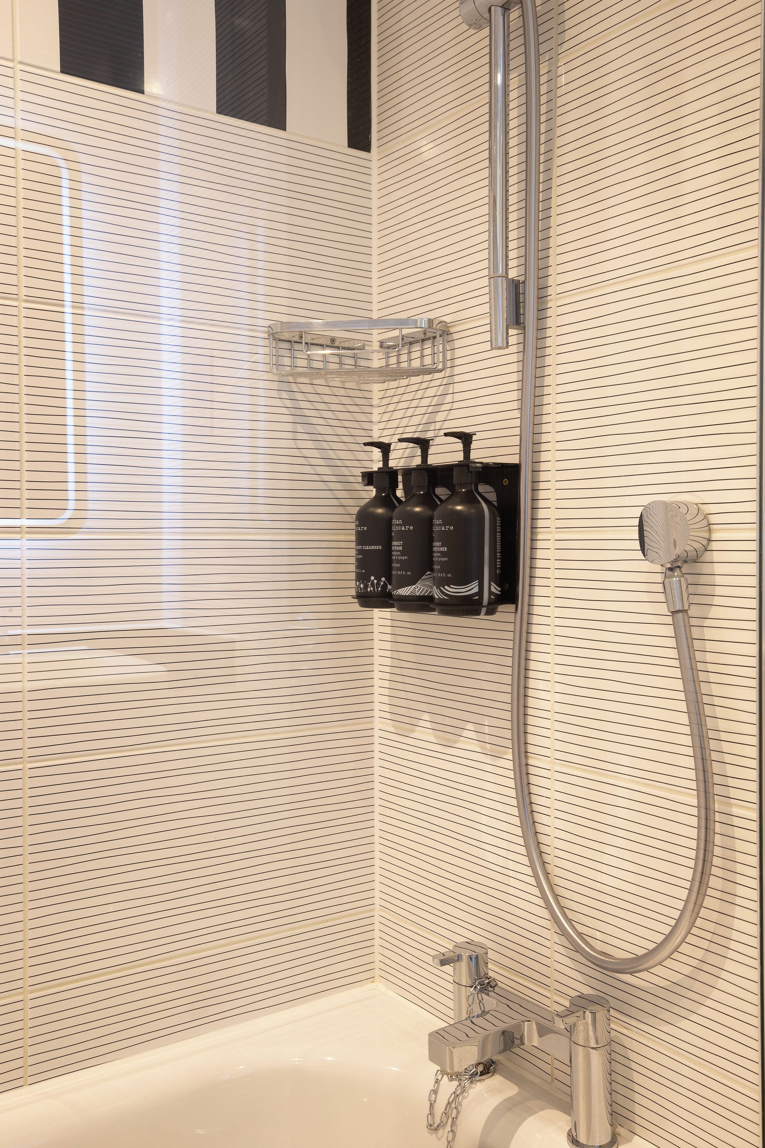 A bathroom with a shower, a bathtub, and a shelf with toiletries.