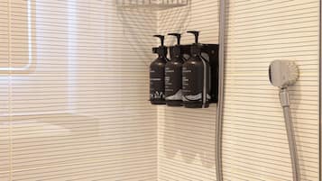 A bathroom with a shower, a bathtub, and a shelf with toiletries.