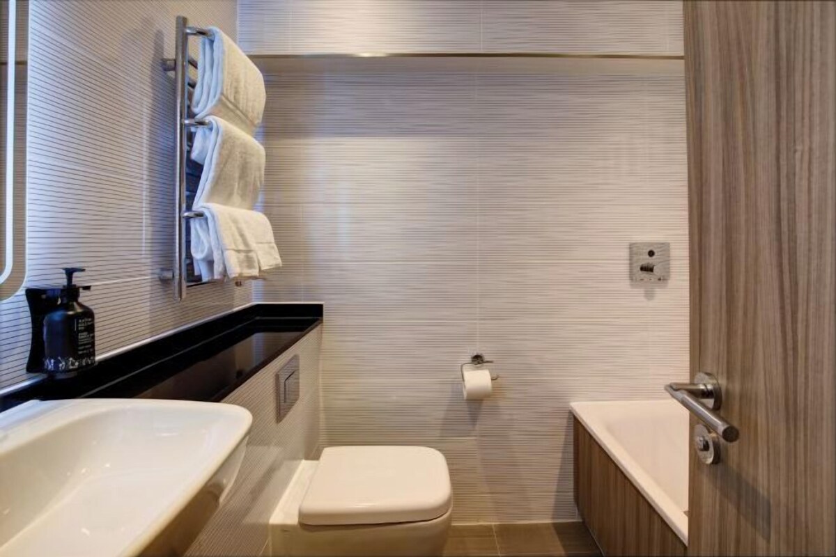 Une salle de bain moderne avec deux vasques, des toilettes et une baignoire.