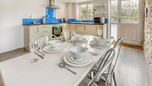 Una cucina moderna con zona pranzo apparecchiata per sei persone.