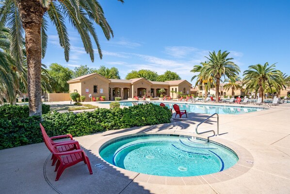A swimming pool with lounge chairs and palm trees. - Upscale Condo | Min from Shopping and Restaurants (Mesa)
