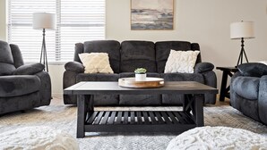 A living room with a grey sofa set, a wooden coffee table, and a floor lamp. - Sunny Peoria Escape w/ Private Pool + Fire Pit (Peoria)