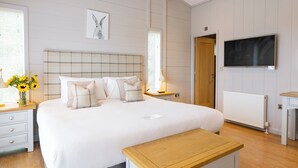 Una camera da letto con un letto, comodini, una TV e una finestra con persiane.