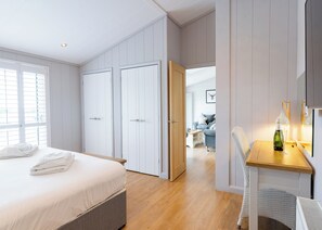 A bedroom with a bed, a desk with a chair, and a wardrobe.