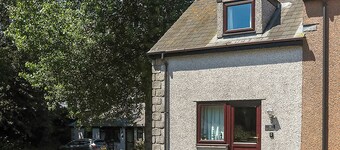 This silver cottage features an open kitchen, dining room, and living room.