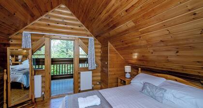 Timber lodge set in an elevated position with views of the lake.