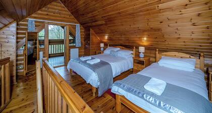 Timber lodge set in an elevated position with views of the lake.