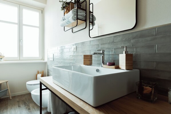A modern bathroom with a large white sink, a mirror, and a window. - Relax by the Pool Among the Vineyards – Villa Ribella (San Damiano D'asti)