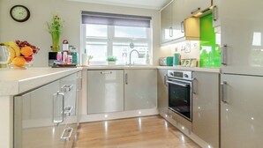 Una cocina moderna con horno empotrado, electrodomésticos de acero inoxidable y una ventana con vistas.