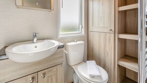 Une salle de bain avec un lavabo, des toilettes et un miroir.
