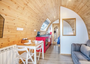 A cozy cabin interior with a wooden ceiling, a dining area, a kitchenette, and a living space. - 0 bedroom accommodation in Great Busby (Great Busby)