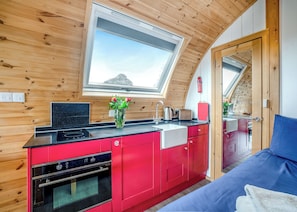A compact kitchen with red cabinets, a black countertop, and a skylight. - 0 bedroom accommodation in Great Busby (Great Busby)