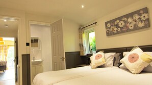Une chambre à coucher avec un lit, une table de chevet et une fenêtre avec des rideaux.