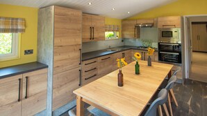 Une cuisine moderne avec des meubles en bois, un îlot central et des appareils électroménagers intégrés.