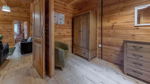 A wooden interior with a sofa, a chair, a cabinet, and a mirror. - 2 bedroom accommodation in Ellesmere (Ellesmere)