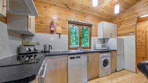 A compact kitchen with a dishwasher, washing machine, microwave, and toaster. - 2 bedroom accommodation in Ellesmere (Ellesmere)