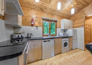 A compact kitchen with a dishwasher, washing machine, microwave, and toaster. - 2 bedroom accommodation in Ellesmere (Ellesmere)