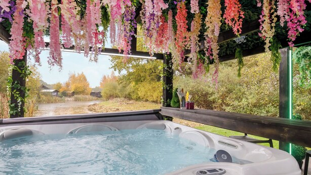 A hot tub with a wooden deck and hanging flowers. - 2 bedroom accommodation in South Duffield, Nr York (South Duffield, Nr York)