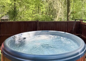 A hot tub on a wooden deck with a forest backdrop. - Woodland Birch Lodge (Ellesmere)
