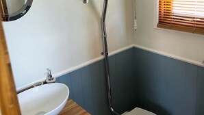 Un baño con lavamanos blanco, inodoro y ducha.