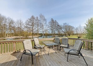 A deck with outdoor furniture, a view of a lake, and trees in the background. - 3 bedroom accommodation in Pickering (Pickering)