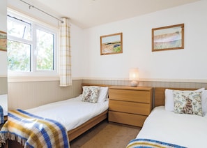 A bedroom with two single beds, a bedside table with a lamp, a window with curtains, and two framed landscape paintings on the wall. - 3 bedroom accommodation in Pickering (Pickering)