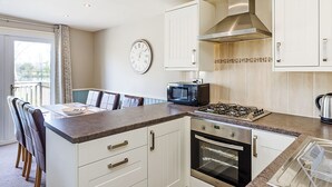 A modern kitchen with white cabinets, a microwave, a stove, and an oven. - 3 bedroom accommodation in Pickering (Pickering)