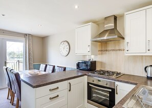 A modern kitchen with white cabinets, a microwave, a stove, and an oven. - 3 bedroom accommodation in Pickering (Pickering)