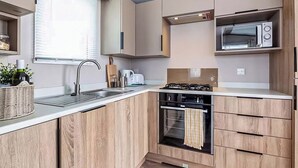 A modern kitchen with a built-in oven, a microwave, and a gas stove.