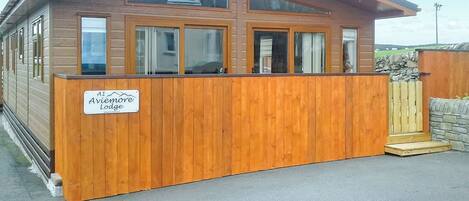 Een houten chalet met een bord waarop 'A1 Aviemore Lodge' staat.