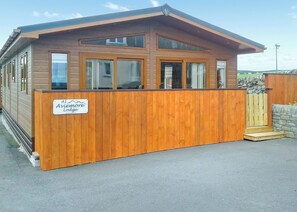 A wooden cabin with a sign reading 'A1 Aviemore Lodge.'