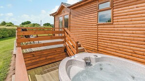 A wooden cabin with a hot tub, wooden deck, and a view of the sky. - Luxury lodge with king-size bed with en suite shower. (Shrewsbury)