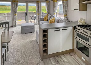 Una cocina compacta con estufa, horno y un comedor con mesa y sillas.