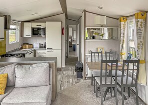 Un espacio habitable compacto con kitchenette, comedor y sofá.