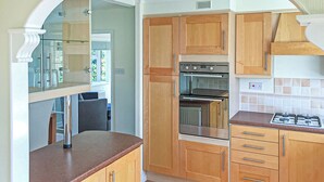 A kitchen with wooden cabinets, a built-in oven, and a gas stove.