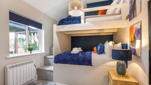 A compact bedroom with a bunk bed, a radiator, a window with a view, and a bedside table with a lamp. - 1 bedroom accommodation in South Duffield, Nr York (South Duffield, Nr York)