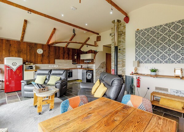 A modern living room with a sofa, coffee table, and a kitchen area in the background.