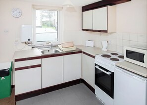 Fridge, oven, stovetop, toaster - This bronze bungalow features an open kitchen, dining room, and living room. (Penzance)