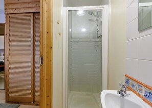 A bathroom with a glass shower enclosure, a wooden door, and a tiled sink area. - 3 bedroom accommodation in Webbery, Bideford (Webbery, Bideford)