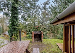 A rustic cabin with a brick fireplace, surrounded by a forest. - 3 bedroom accommodation in Webbery, Bideford (Webbery, Bideford)