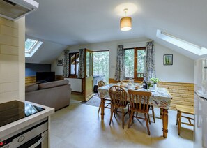 Une cuisine chaleureuse avec un coin repas, un canapé et un téléviseur.
